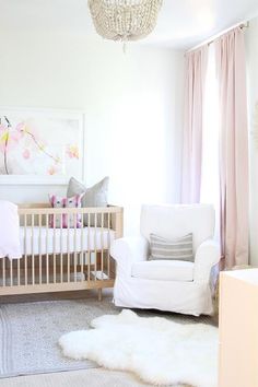 a baby's room with a white crib and pink curtains