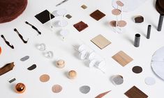 an assortment of objects are arranged on a white surface, including wood and metal pieces