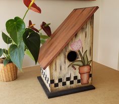 a birdhouse with a potted plant next to it