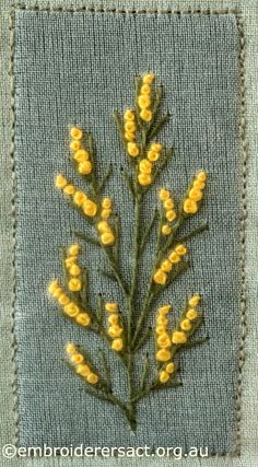 yellow flowers are embroidered onto the back of a blue jeanette jacket, which is stitched into an applique