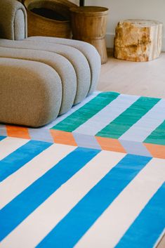 a striped rug is on the floor next to a couch