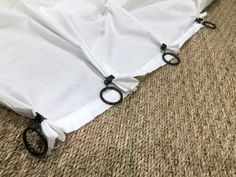 two pairs of scissors are tied to the side of a white sheet on the floor