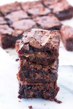 three chocolate brownies stacked on top of each other with one bite taken out of it