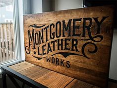 a wooden sign that says montgomery leather works on the side of a window sill