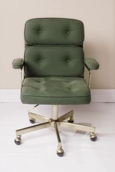 a green office chair sitting on top of a white floor