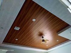 a ceiling fan mounted to the side of a wooden paneled ceiling in a room