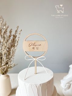 a white cake topped with a wooden sign