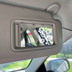 the interior of a car is shown with purple flowers in the center window and on the passenger side mirror