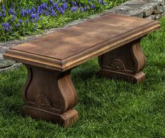 a wooden bench sitting on top of a green grass covered field next to purple flowers