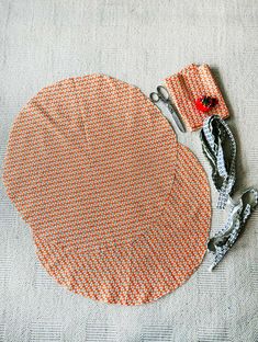 an orange and white cloth with scissors on top of it next to some other items