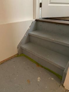 an empty step leading up to a door in a house that has been painted white