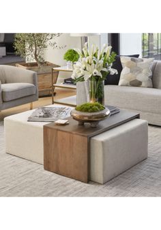 a living room filled with furniture and flowers on top of a coffee table in front of a couch