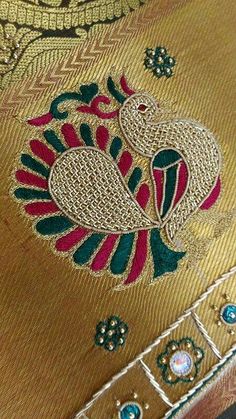 a close up view of a gold and green brocade with peacocks on it