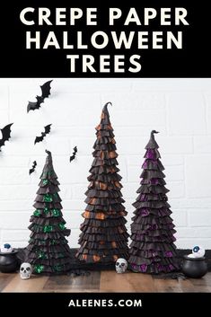 three halloween trees made out of paper with bats and skulls on the wall behind them