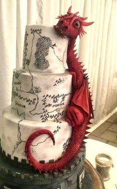 a three tiered cake with a red dragon on top