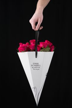 a person holding a white paper umbrella with red roses in it and the words thomas scholl on it