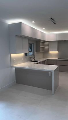 an empty kitchen with white counter tops and stainless steel appliances