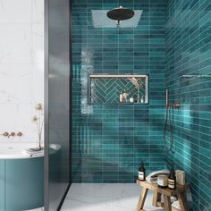 a blue tiled bathroom with a wooden stool