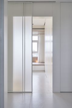 an open door leading to a bathroom with white walls