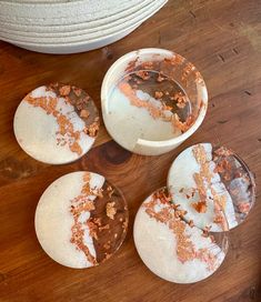 four pieces of cake sitting on top of a wooden table next to a white bowl