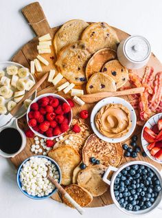 pancakes, fruit, and other foods are arranged on a wooden platter with the words how to build a pancake board for food