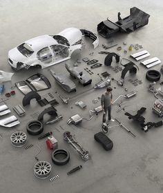 a man standing in front of an assortment of parts for a car on the ground