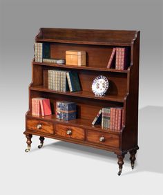 an old bookcase with many books on it and a clock in the top shelf