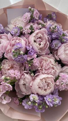 a bouquet of pink and purple flowers in a paper wrapper