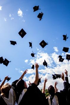 graduates throwing their caps in the air at graduation ceremony with blue sky and white clouds