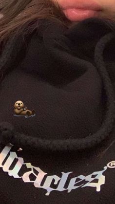 a close up of a person wearing a hoodie with a skull on the side