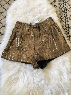 Add some sparkle to your wardrobe with these Alice + Olivia by Stacey Bendet gold sequin shorts. The pull-on style features a flat front and mid-rise fit, with a waist size that can be seen in the pictures. Made of polyester with accents of sequin, these shorts are perfect for a night out or a special occasion. The size 10 shorts are brand new with tags, and have a suggested retail price of $495. They are a regular fit and regular size type, suitable for women's department. The theme of the shor Trendy Gold Bottoms For Parties, Trendy Party Shorts For Fall, Trendy Fall Party Shorts, Metallic Sequined Bottoms For Summer, Metallic Sequined Bottoms For Spring, Metallic Sequined Bottoms For Holiday, Gold Sequined Bottoms For Fall, Metallic High-waisted Shorts For Party, Gold Bottoms With Built-in Shorts For Summer