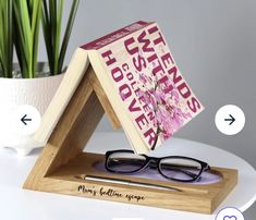 a pair of glasses sitting on top of a wooden stand next to a potted plant