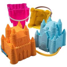 three plastic sandcastles are shown in different colors