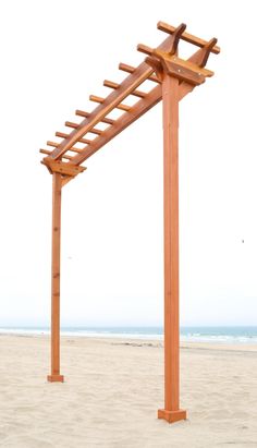 a wooden pergol on the beach with waves in the background