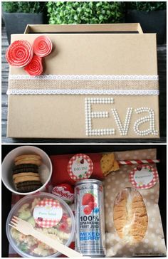 an open box filled with food and some paper flowers next to other items on the table