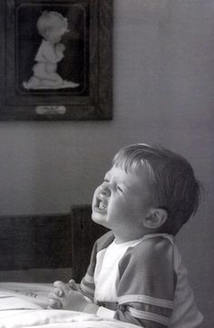 a black and white photo of a baby laughing