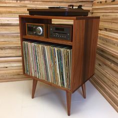 an old record player is sitting on top of a wooden cabinet