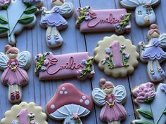 decorated cookies are arranged in the shape of fairy's and flowers on a table