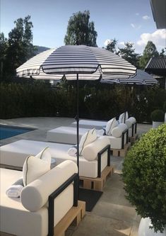 an outdoor patio with white couches and umbrellas