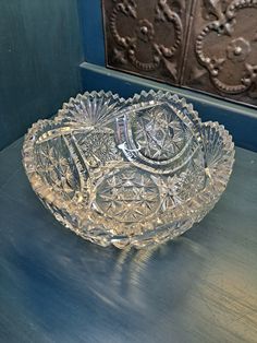 a glass bowl sitting on top of a wooden table next to a metal door handle