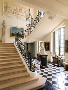 an ornate staircase in the middle of a room with paintings on the walls and floor