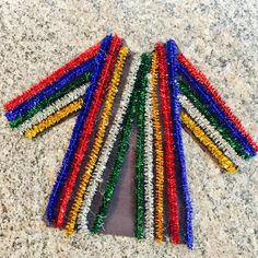 multicolored beads are laid out on the floor to be used as bracelets