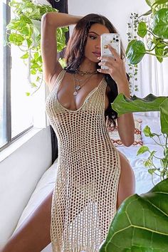 a woman taking a selfie in a white crochet dress