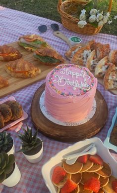 a table topped with cakes and desserts on top of a checkered table cloth