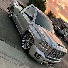 the silver truck is parked on the side of the road