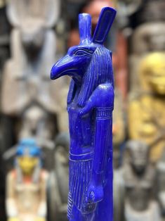 a blue statue is standing in front of other statues