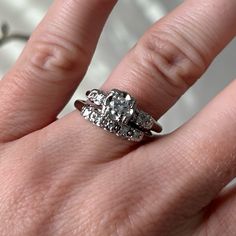 a woman's hand with two wedding rings on it