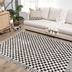 a living room with a white couch and black and white checkered rug on the floor