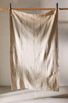 an old cloth hanging on a clothes line in a room with white walls and flooring