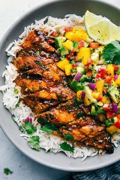 a bowl filled with rice, chicken and pineapple salsa